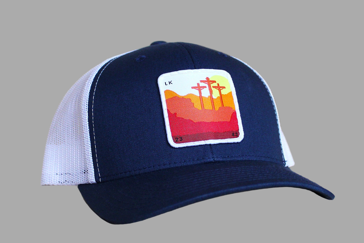 Navy blue and white trucker hat with a colorful patch on a wooden surface
