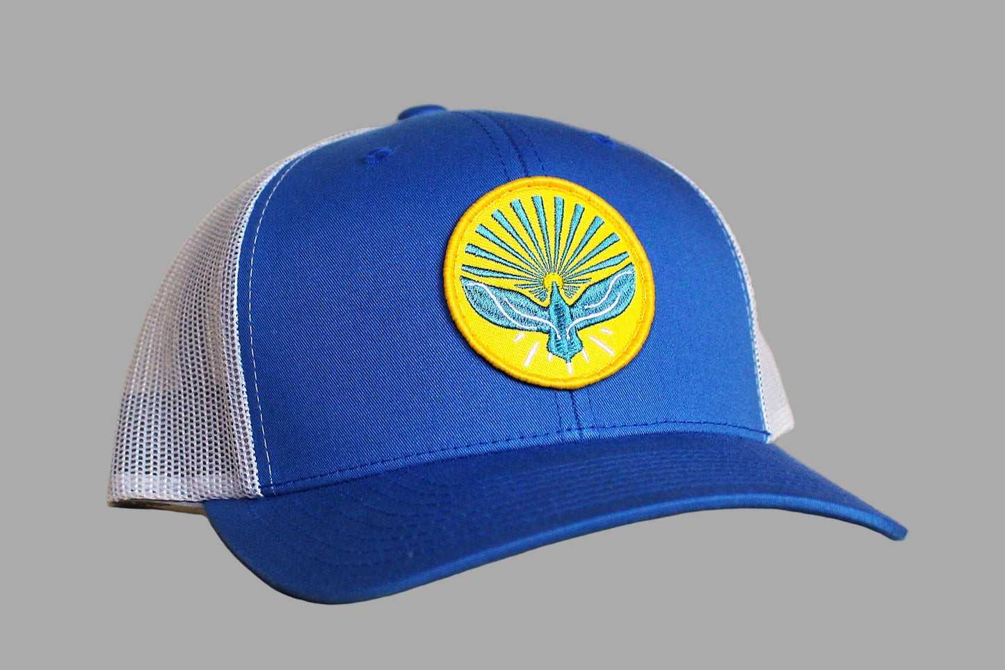 Blue cap with a yellow and blue emblem on a wooden surface