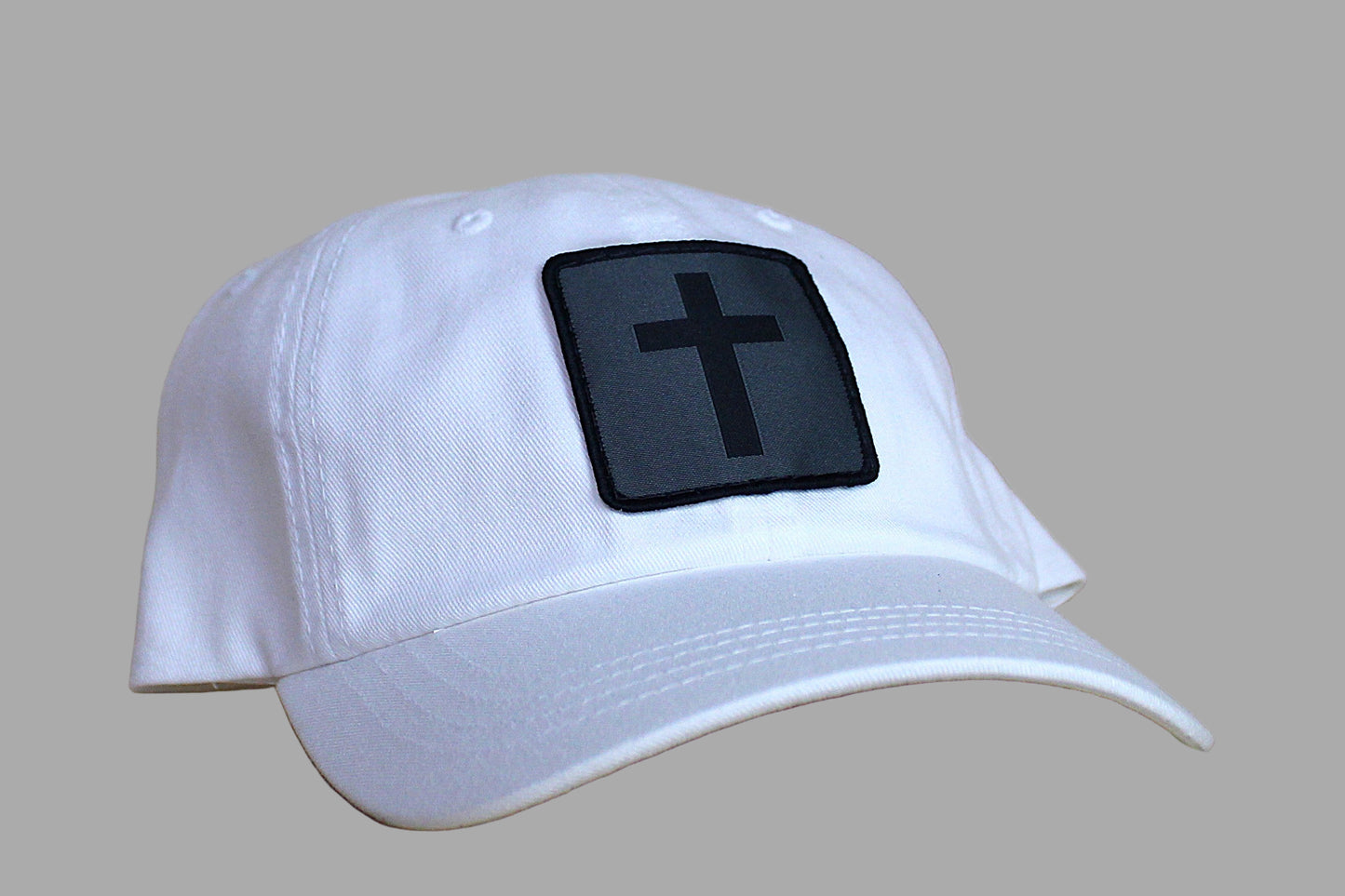 White cap with a black cross patch on a wooden surface