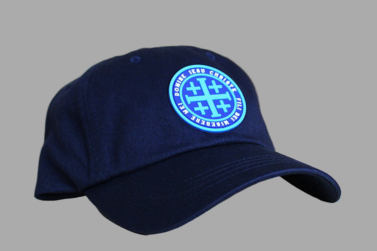 Navy blue cap with a blue logo on a light wooden surface