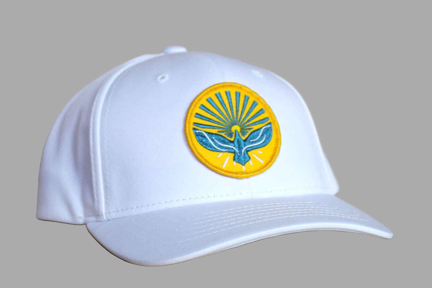 White cap with a yellow and blue emblem on a wooden surface