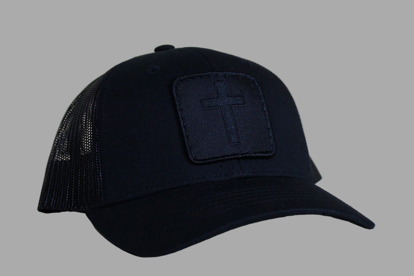 Black cap with a cross patch on a light wooden surface