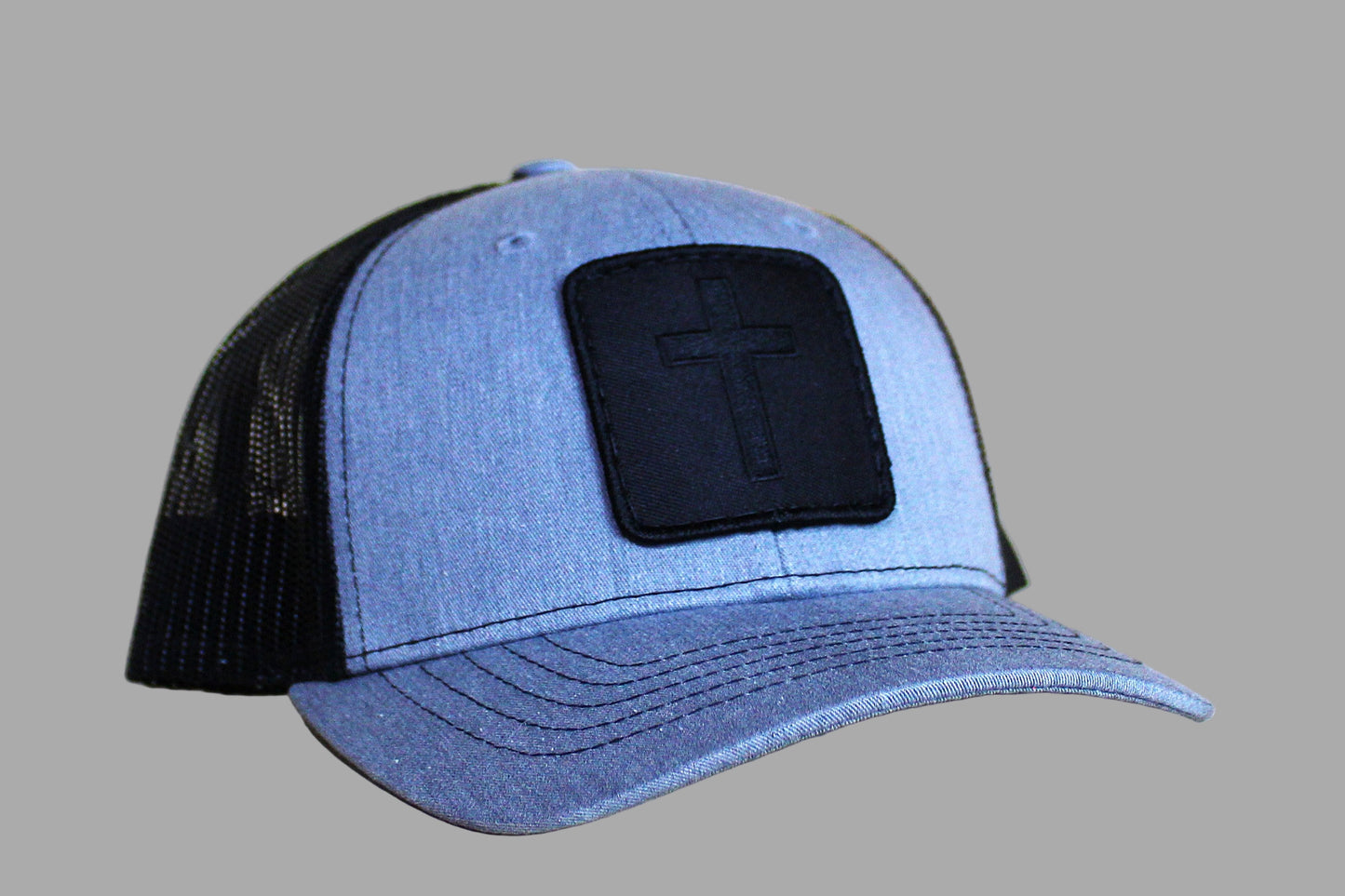 Blue and black cap with a logo patch on a light wooden surface