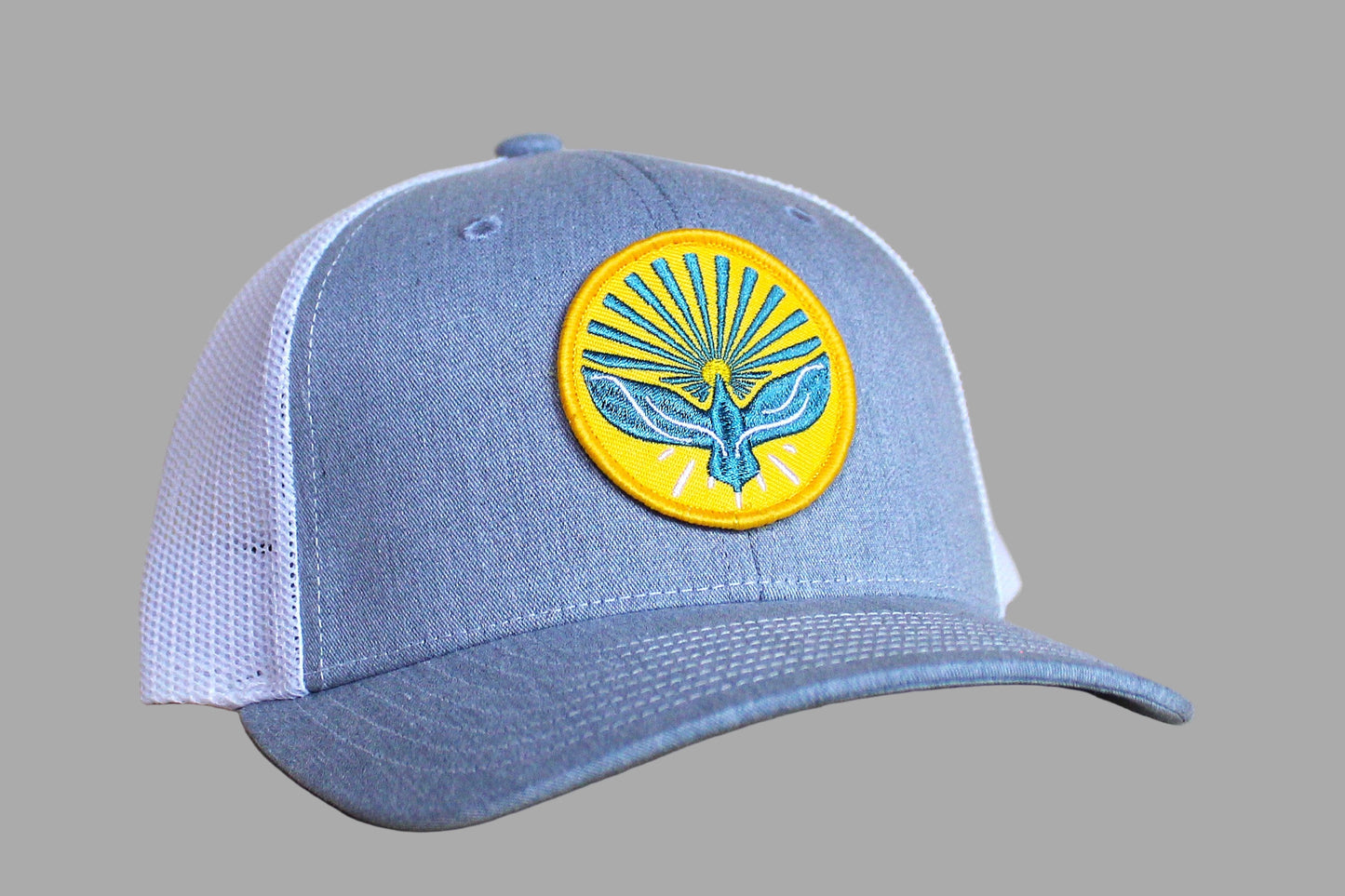 Blue cap with a yellow and blue emblem on a wooden surface