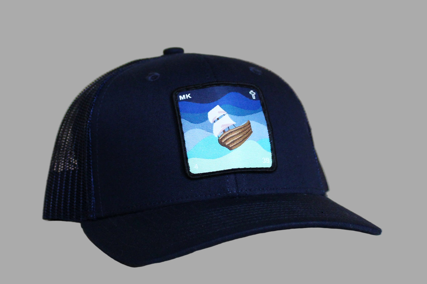 Navy blue cap with a ship patch on a wooden surface