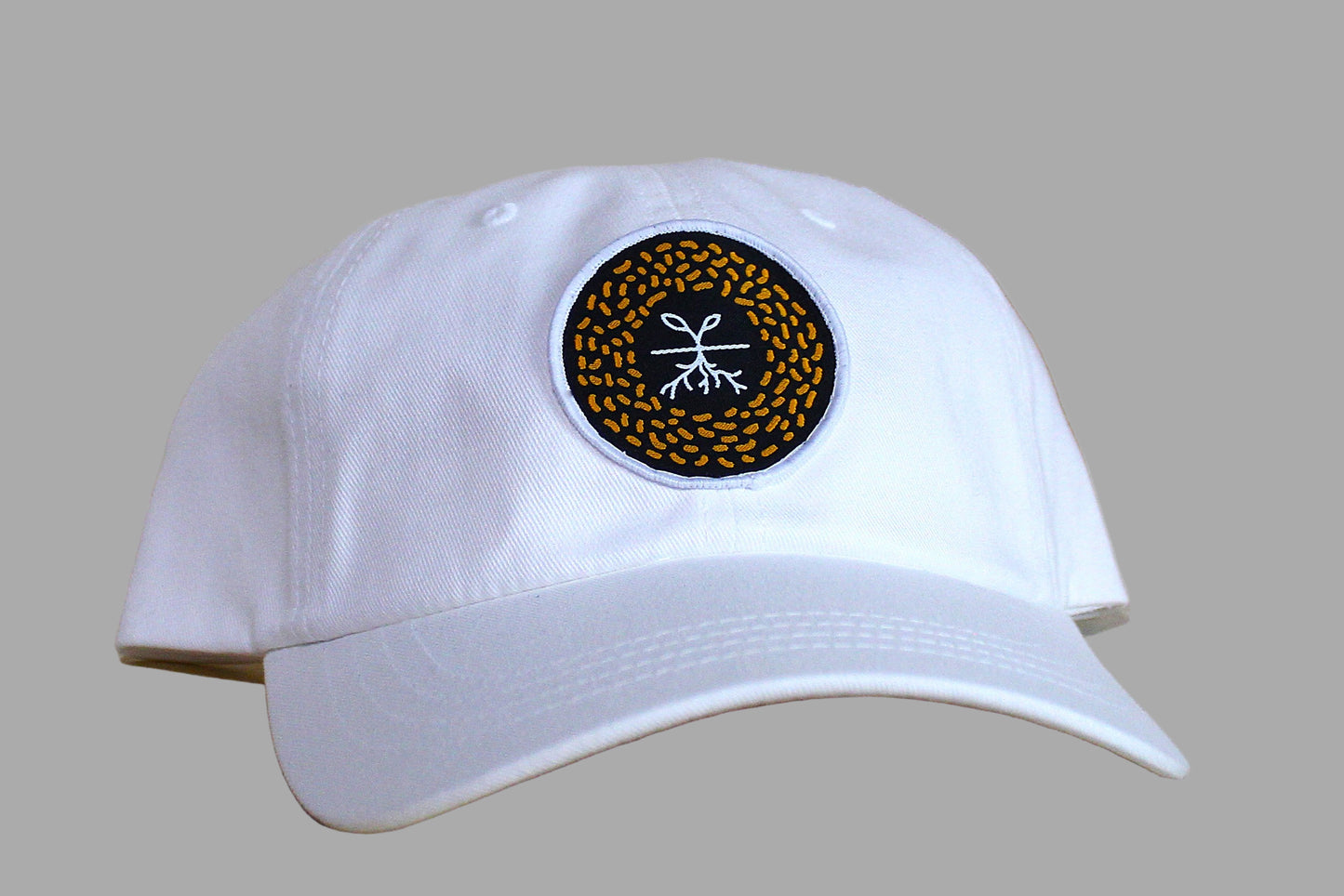 White cap with a circular logo on a wooden surface
