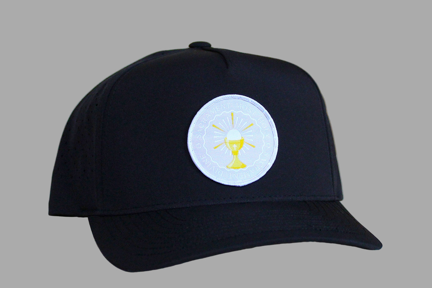 Black cap with a white emblem featuring a yellow design on a light wooden surface.