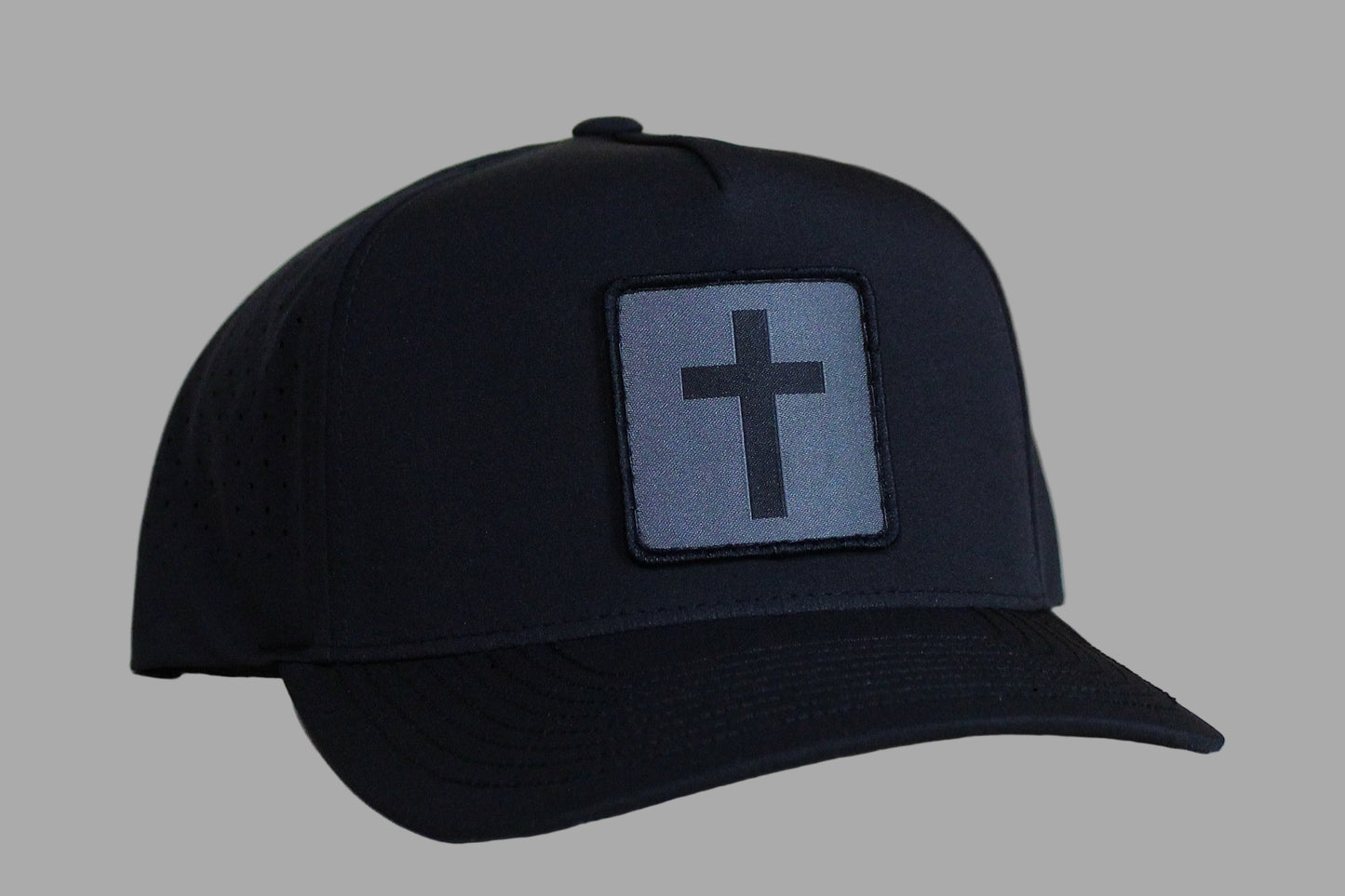 Black cap with a cross patch on a light wooden surface