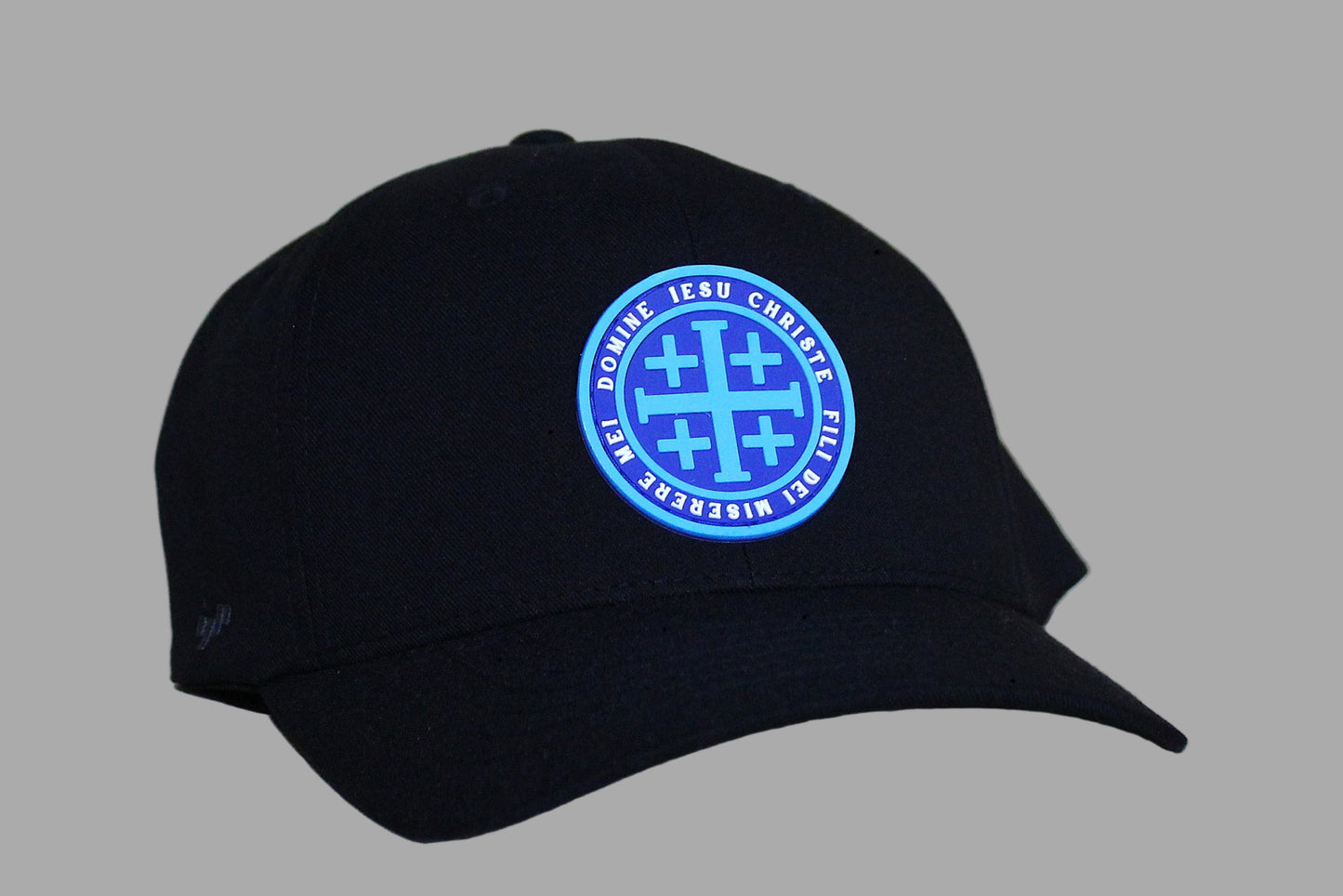 Black cap with a blue embroidered logo on a light wooden surface
