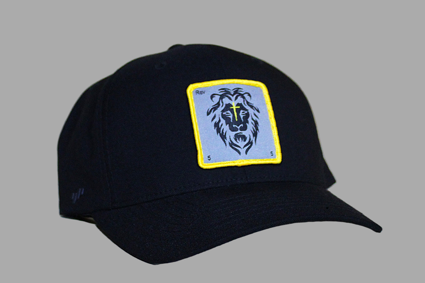 Black cap with a lion emblem on a light wooden surface