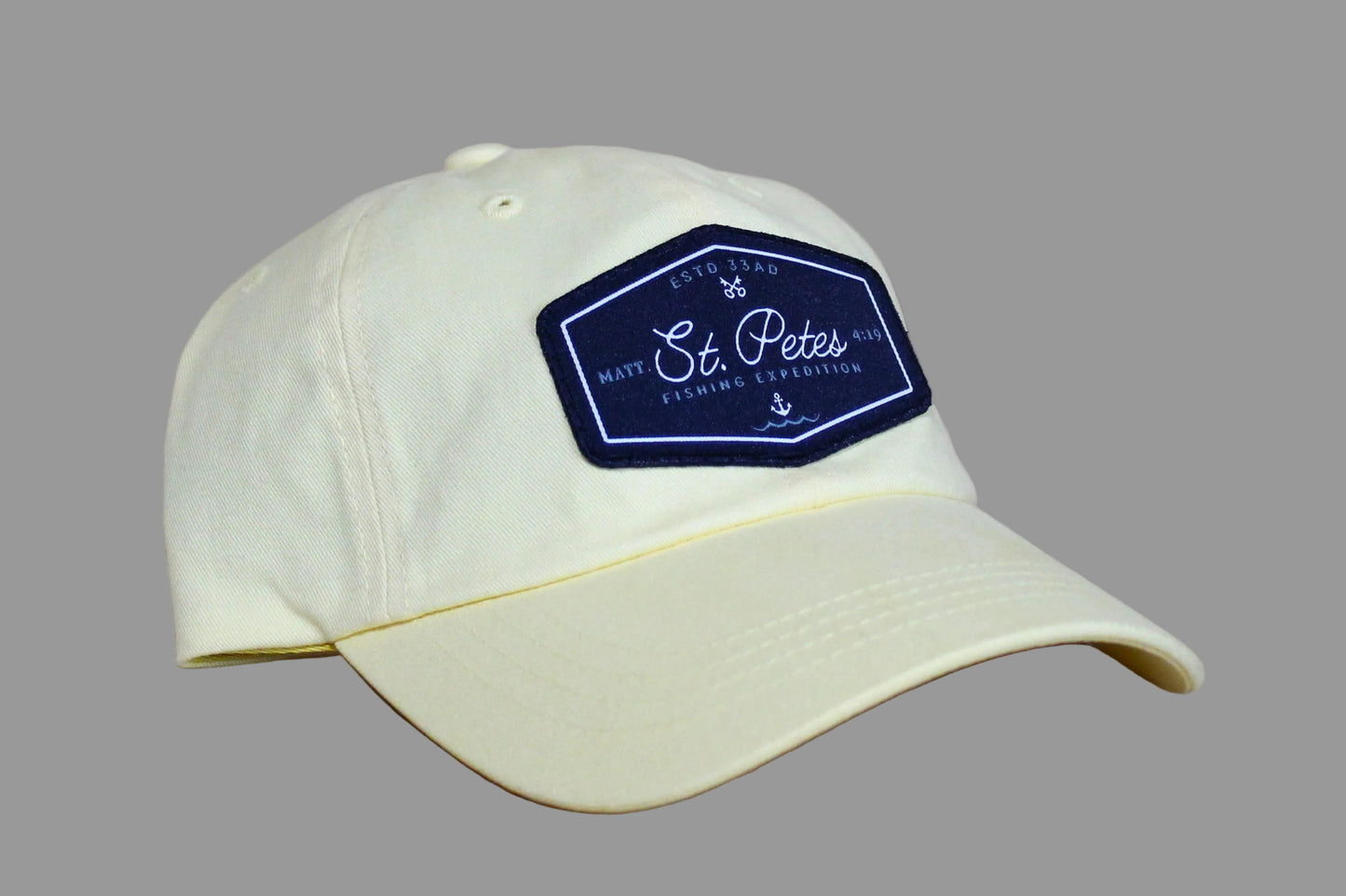 Light-colored baseball cap with a dark blue patch o