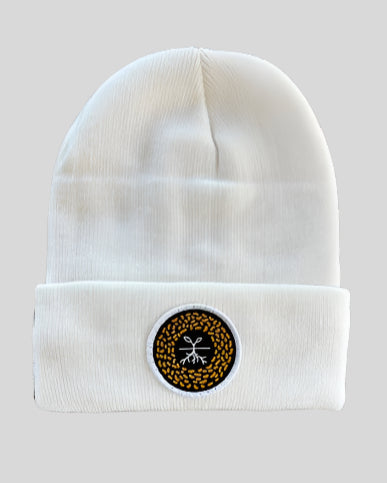 White winter hat with a mustard seed patch
