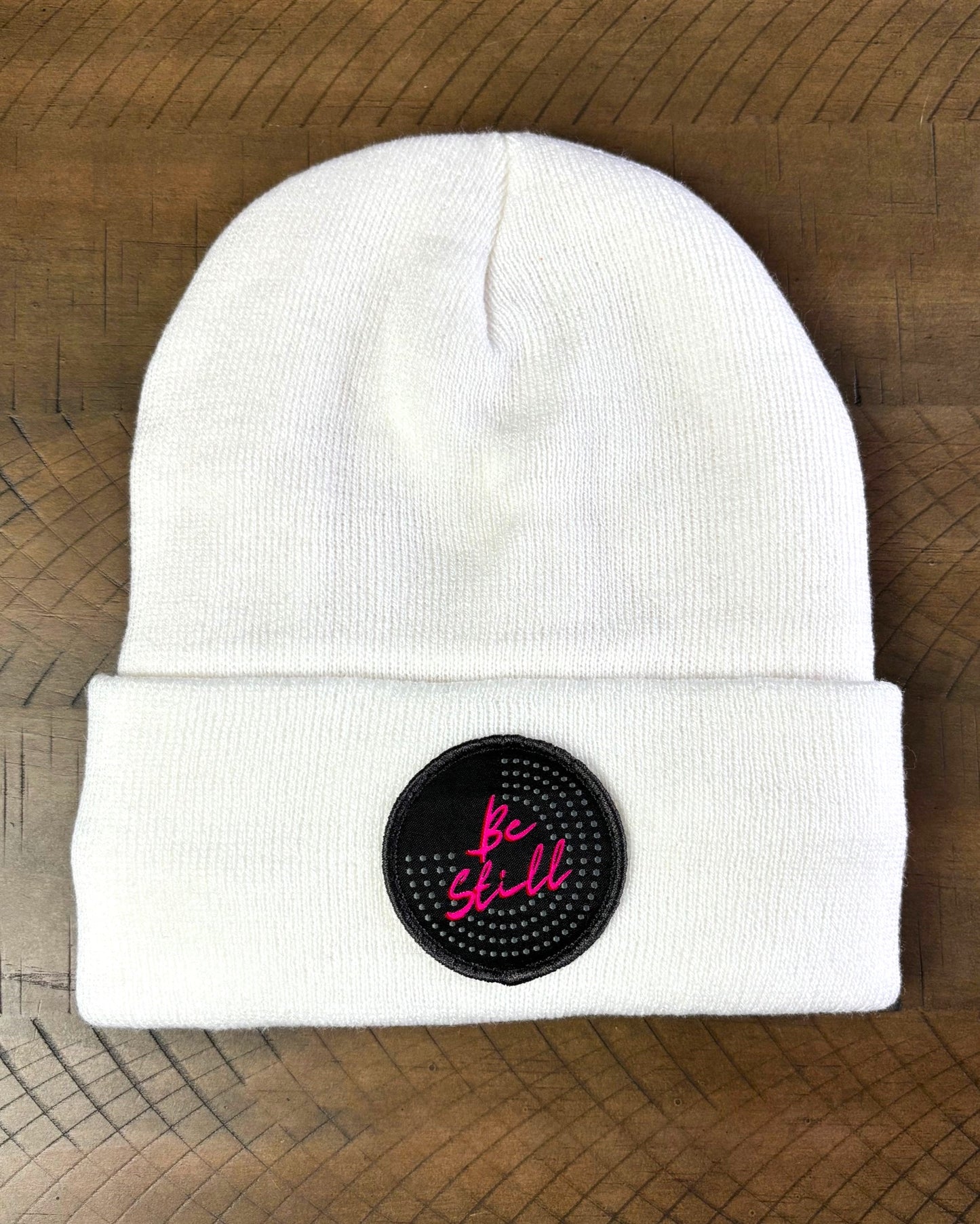 White winter hat with a Be Still patch