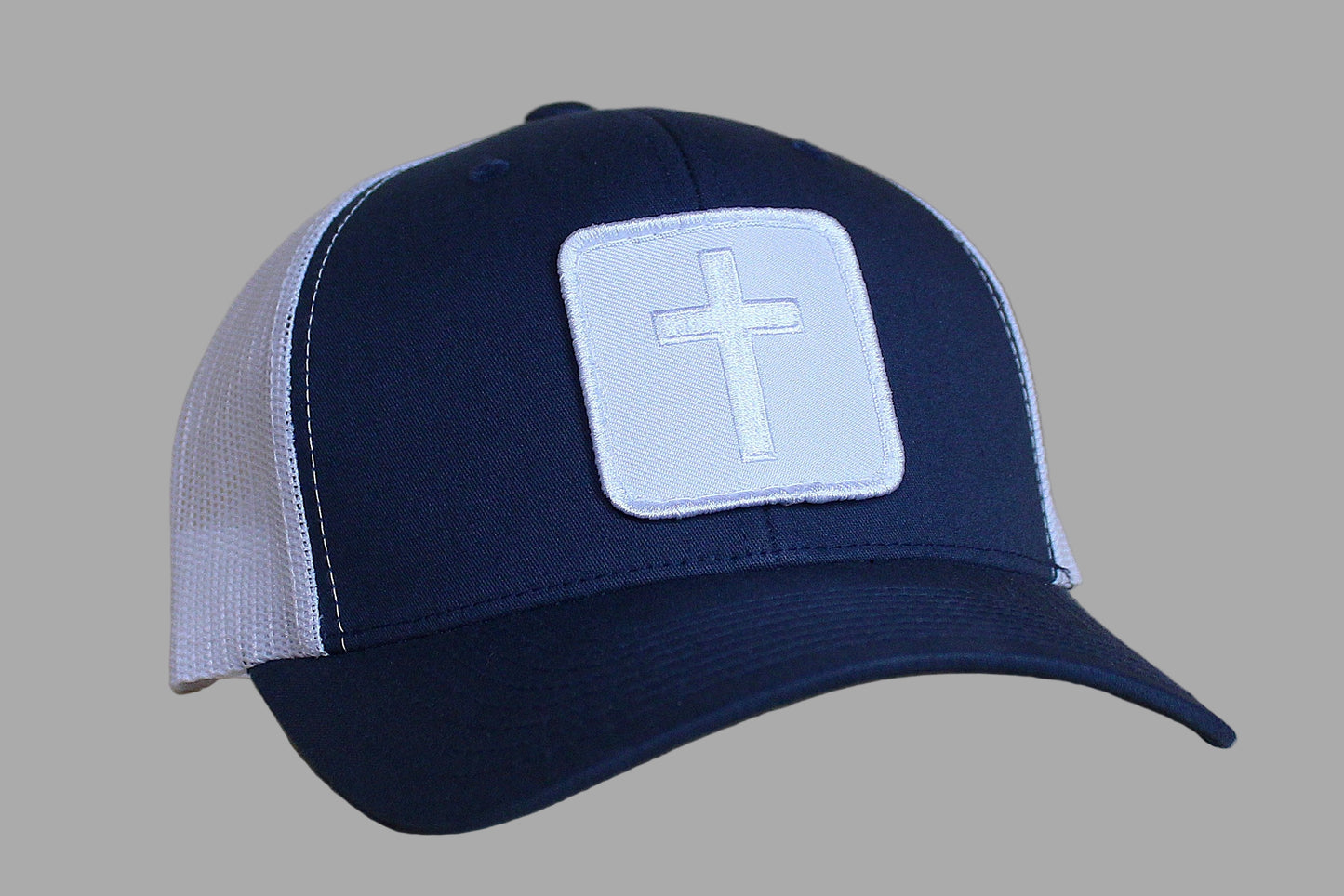 Navy blue cap with a white cross patch on a gray background