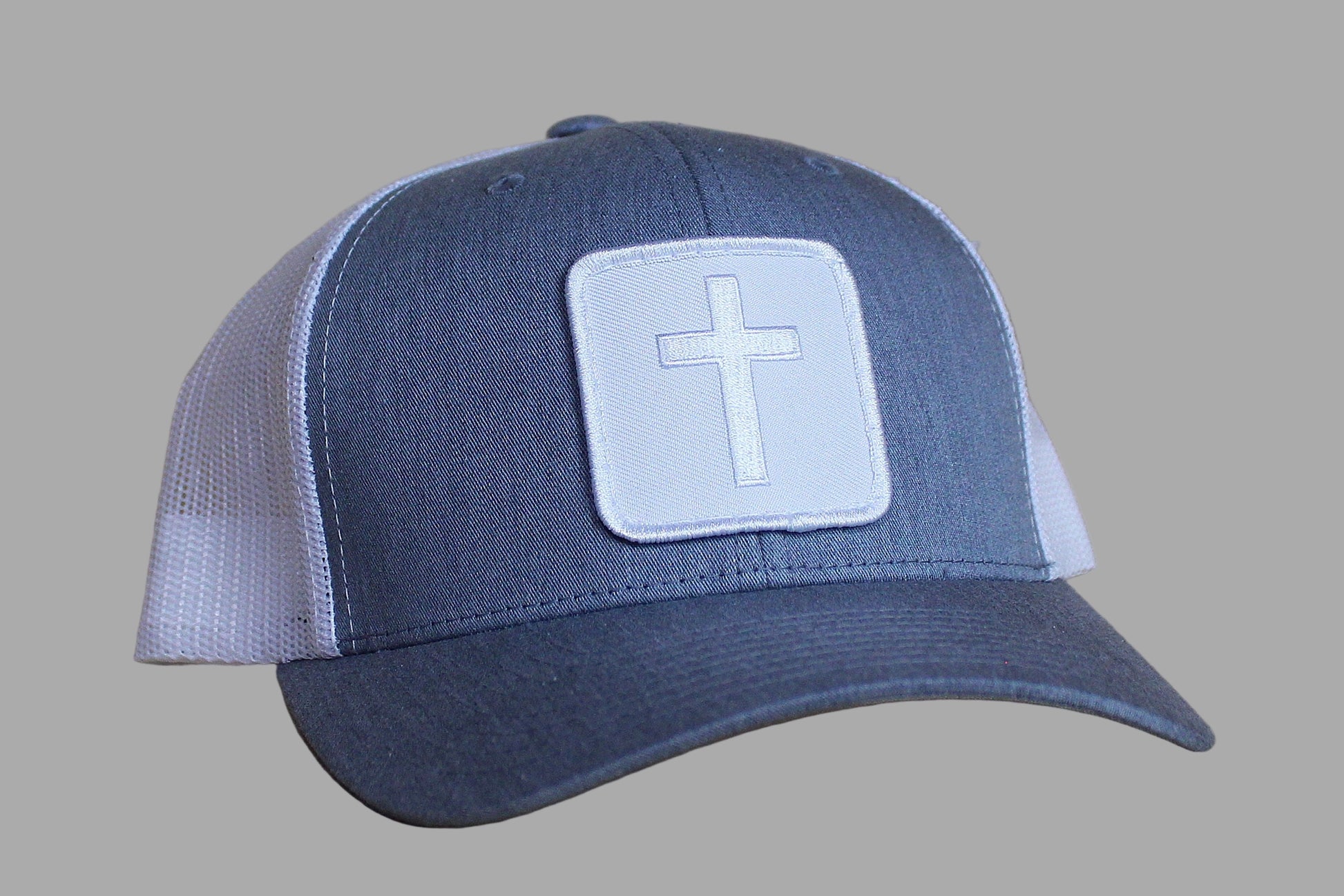 Blue and white cap with a cross patch on a wooden surface