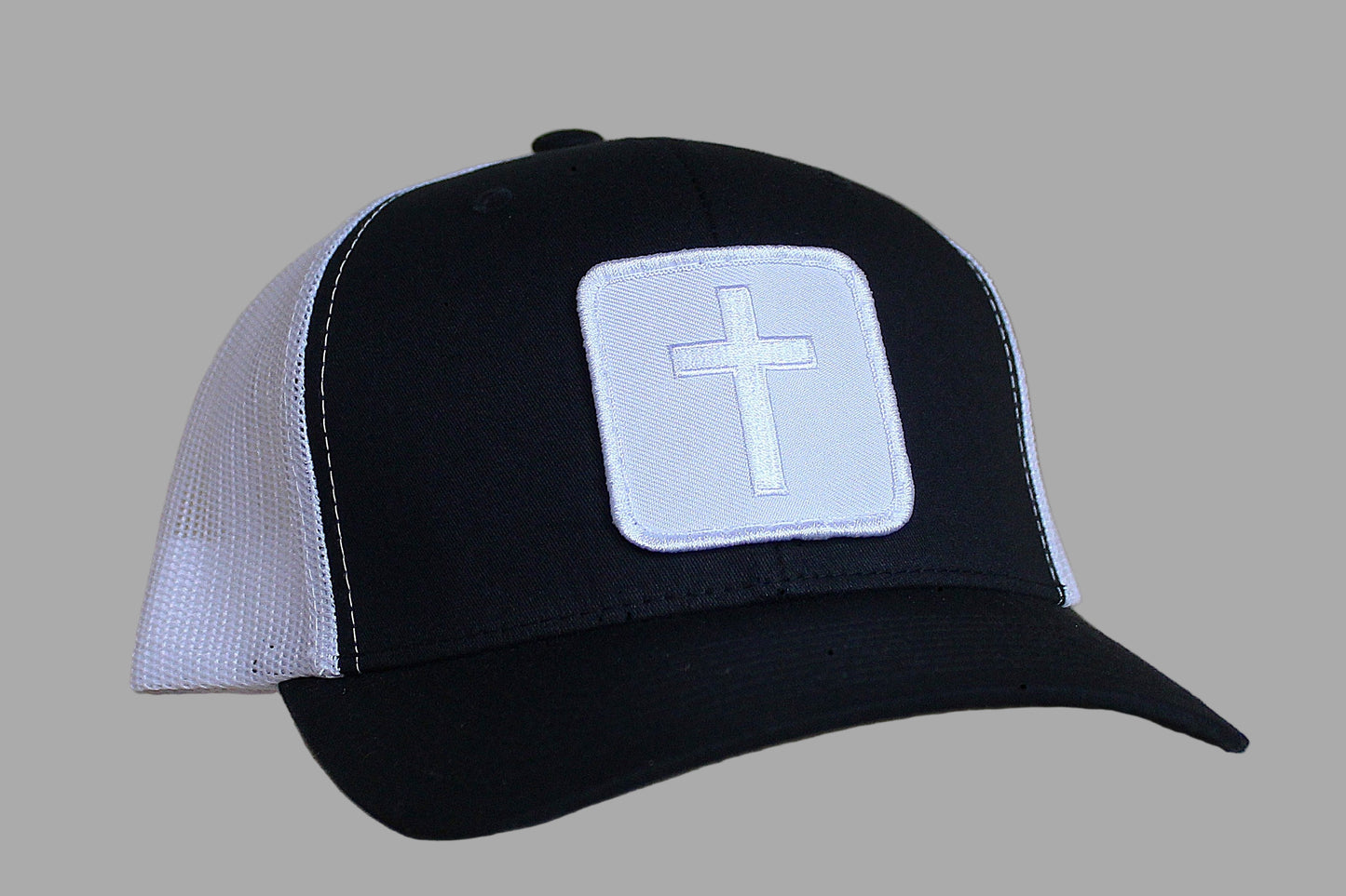 Black and white cap with a cross emblem on a gray background