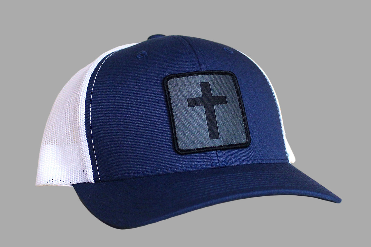 Blue and white cap with a cross patch on a gray background