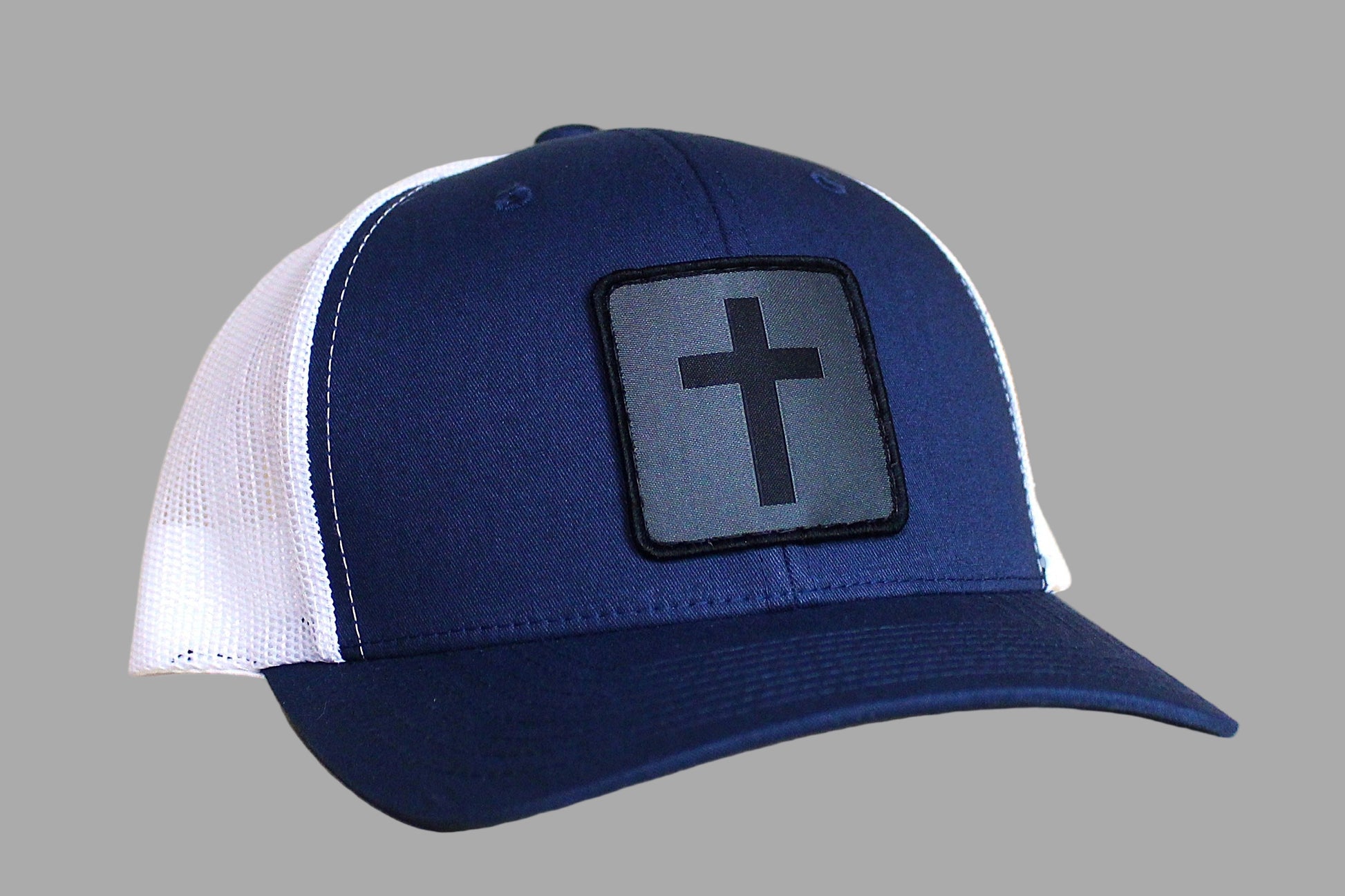 Blue and white cap with a cross patch on a gray background