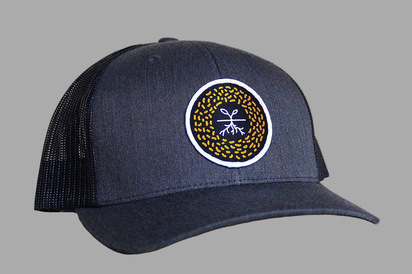 Navy blue cap with a circular logo on a light wood background
