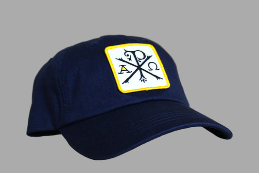 Navy blue cap with a logo on a light wooden surface