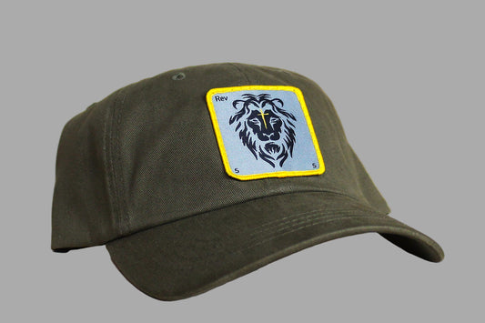 Green cap with a lion emblem patch on a wooden surface