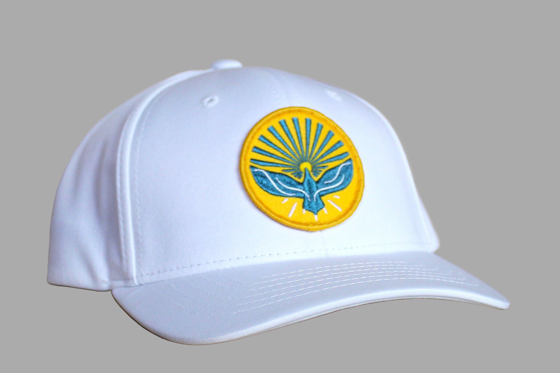 White cap with a yellow and blue emblem on a wooden surface