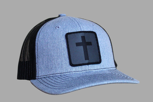 Blue and black cap with a cross emblem on a wooden surface