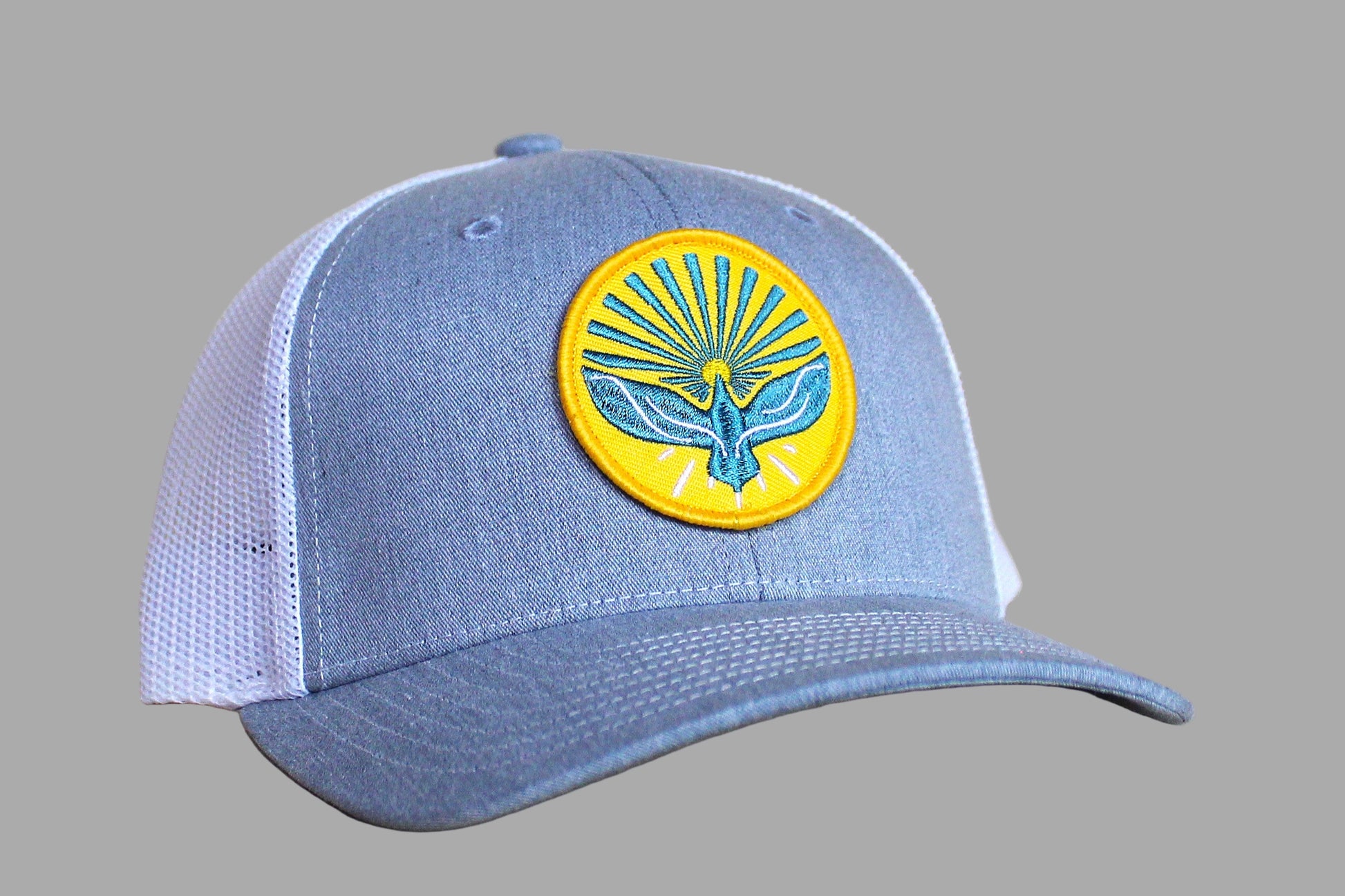 Blue cap with a yellow and blue emblem on a wooden surface