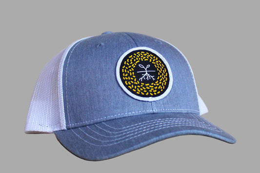Blue and white cap with a circular logo on a wooden surface