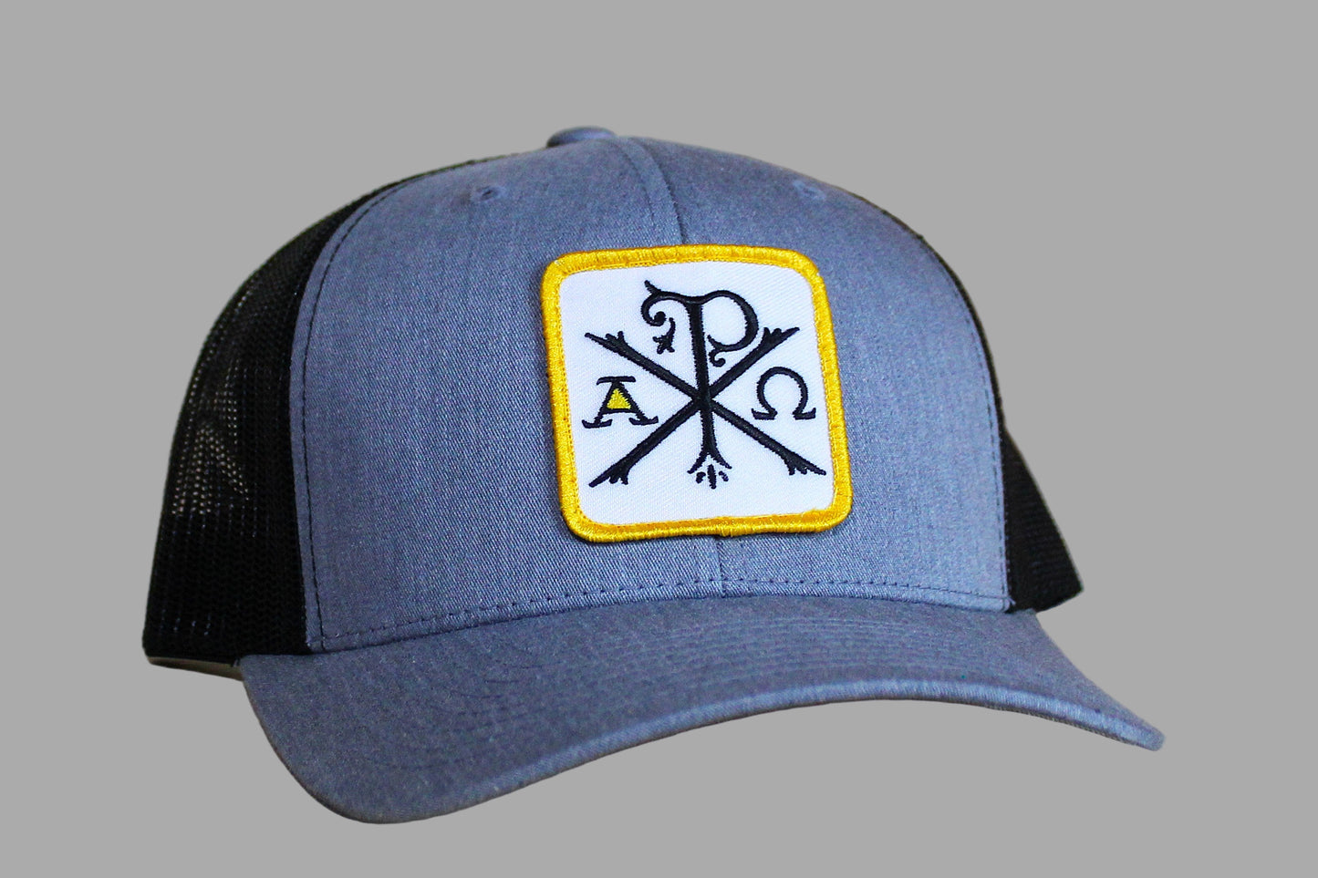 Blue and black cap with a patch featuring symbols on a wooden surface