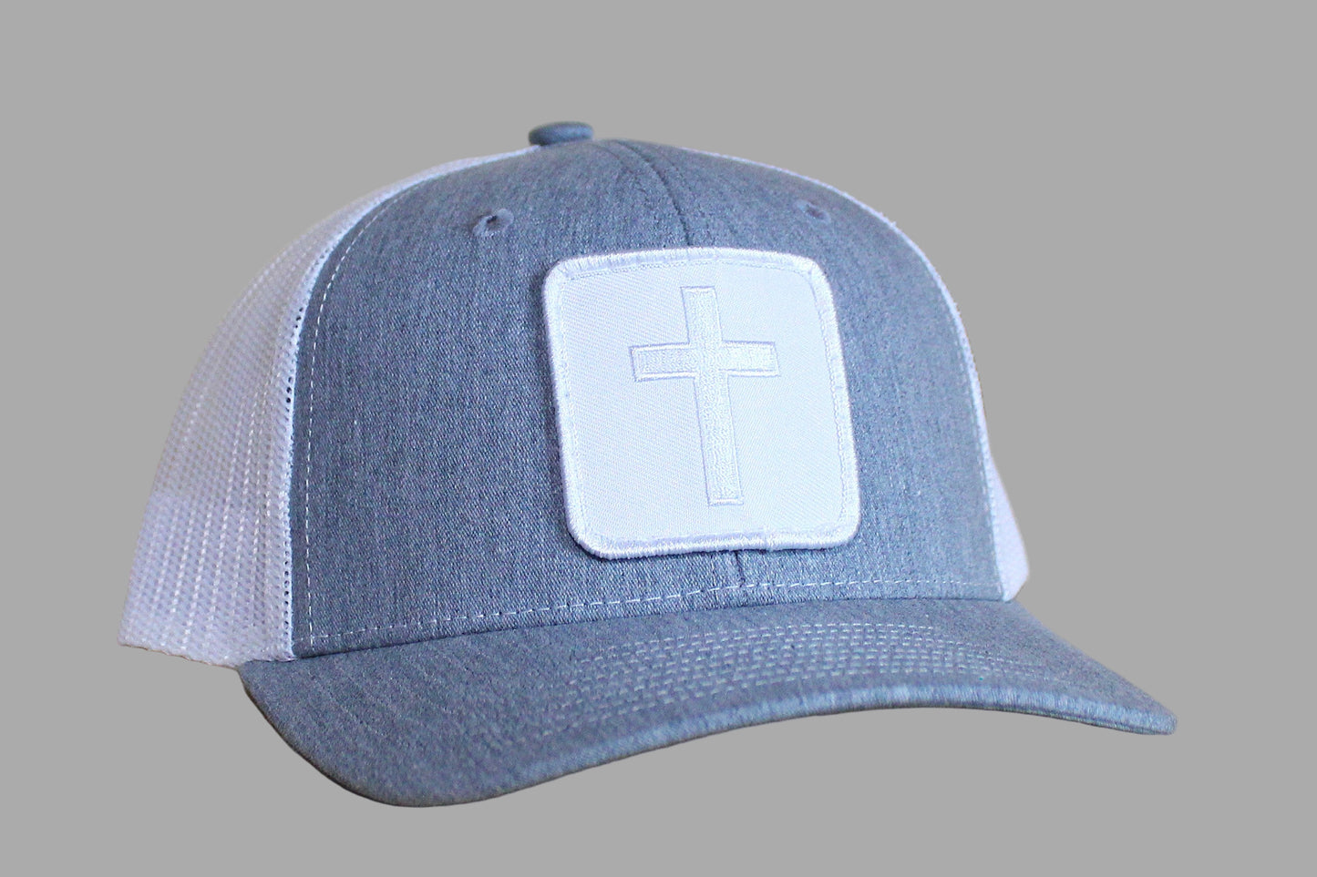 Blue and white cap with a cross patch on a wooden surface