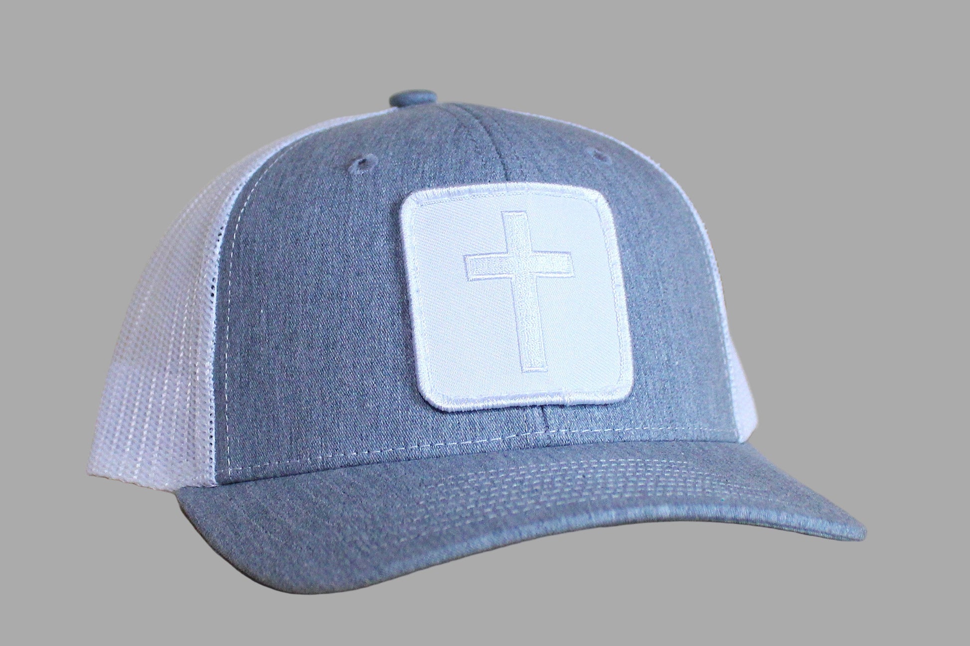 Blue and white cap with a cross patch on a wooden surface