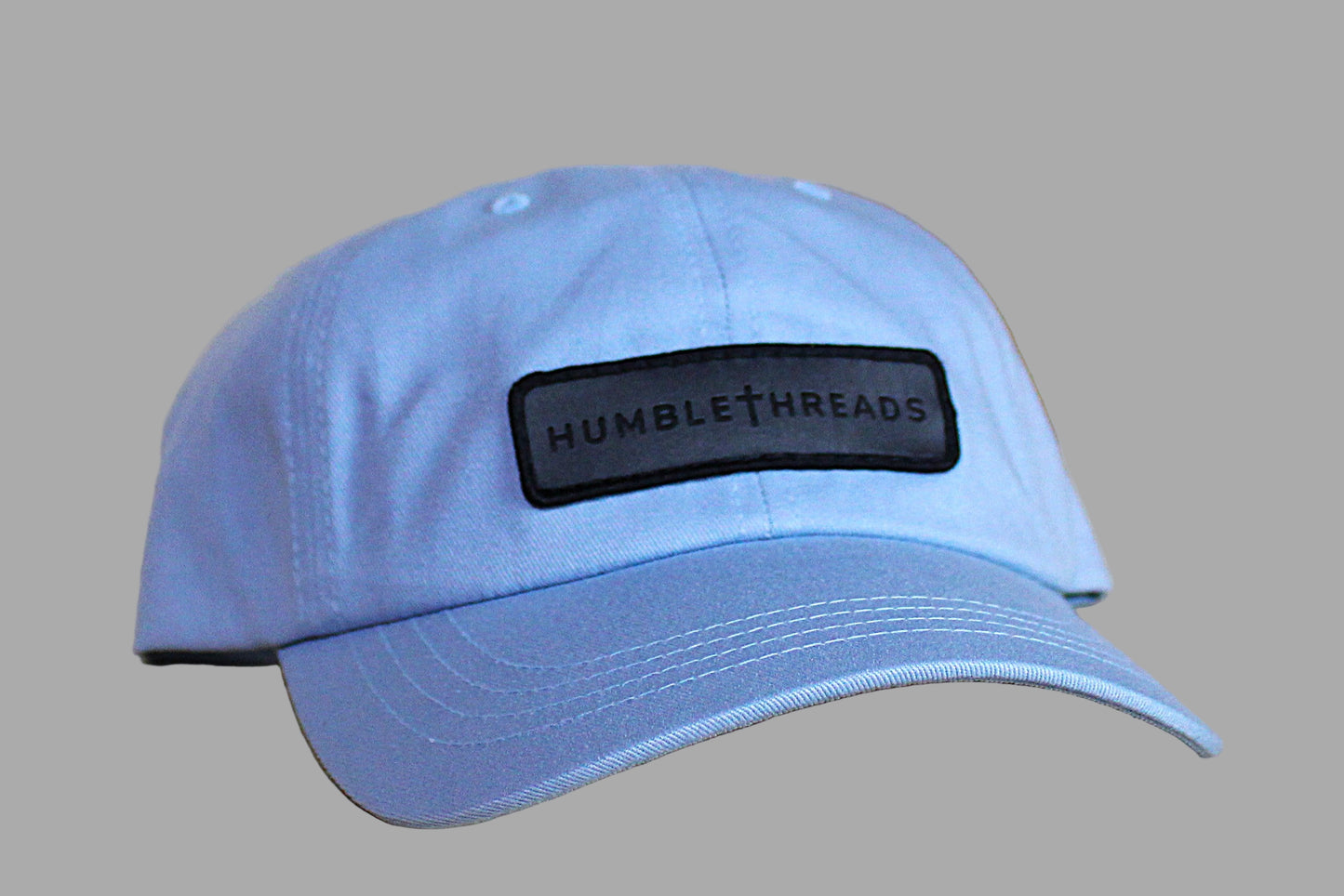Light blue cap with a black patch on a wooden surface
