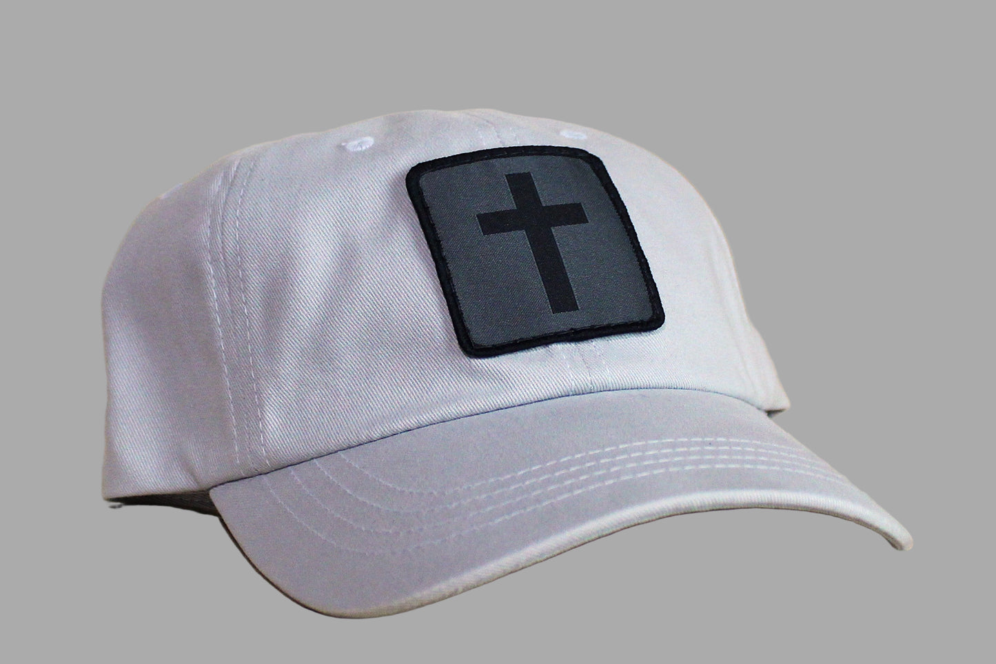 Gray cap with a black cross patch on a wooden surface