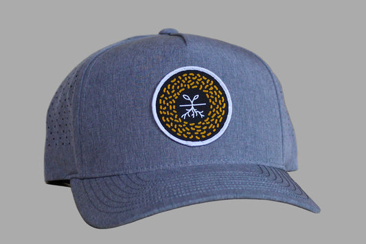 Gray cap with a circular logo on a wooden surface