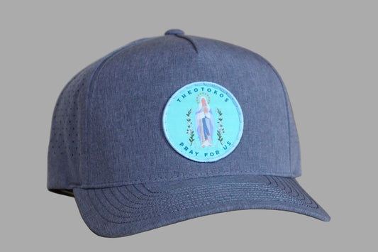 Blue baseball cap with a circular patch featuring a religious icon on a wooden surface.