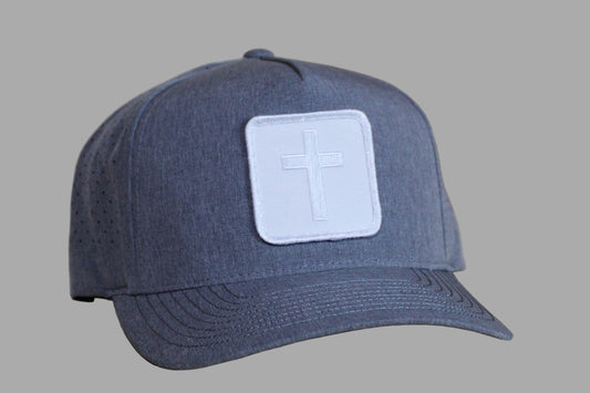 Blue cap with a white patch featuring a cross on a wooden surface