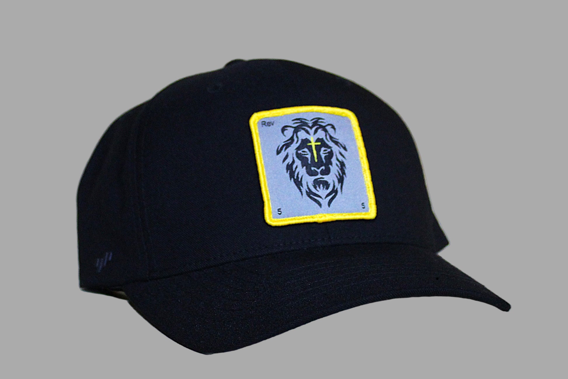 Black cap with a lion emblem on a light wooden surface