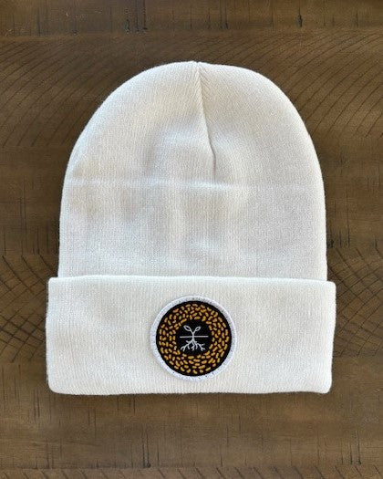 White winter hat with a mustard seed patch