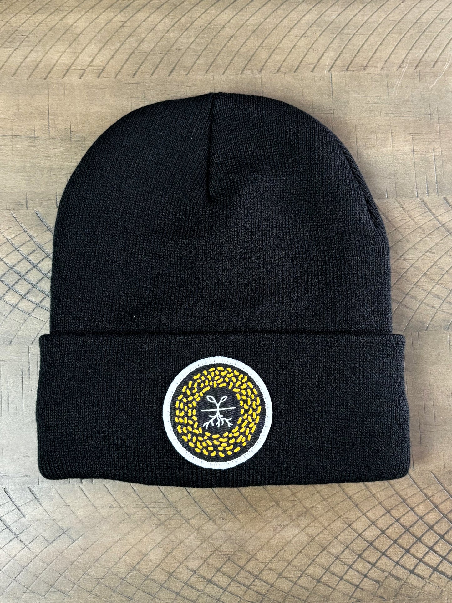 Black winter hat with a mustard seed patch